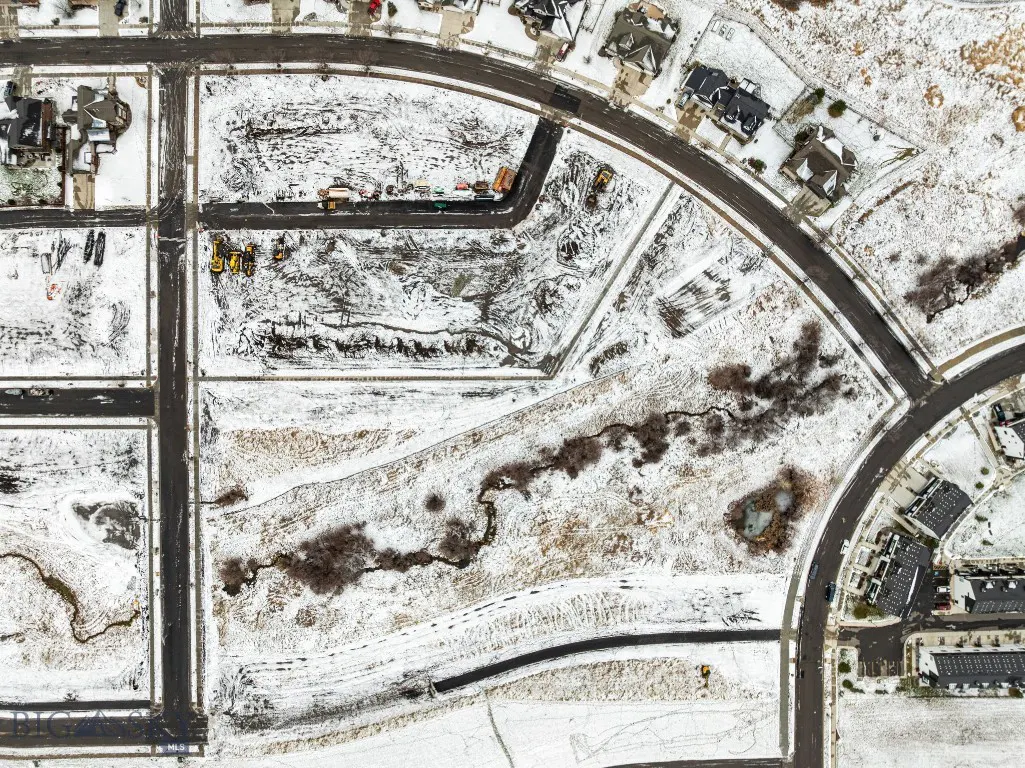 Aerial view of snowy Meadow Bridge development with winding creek corridor